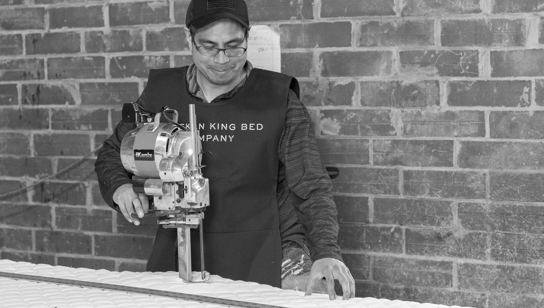 Employee sewing a mattress in the factory