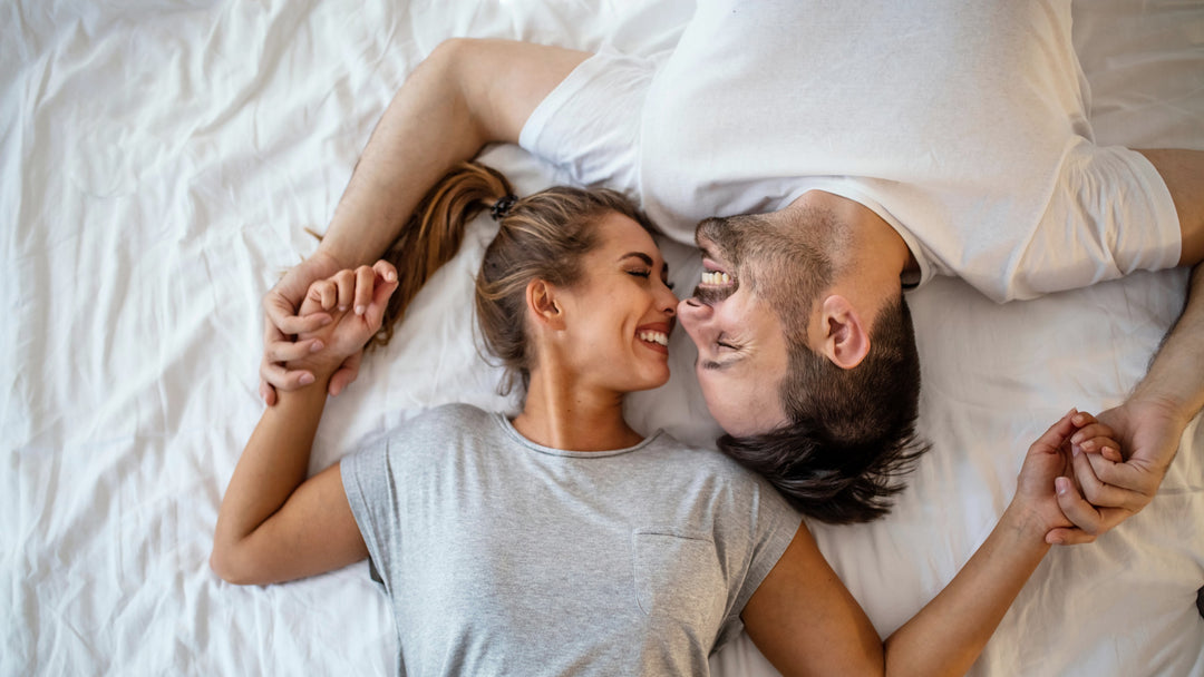 Happy man and woman lying in bed